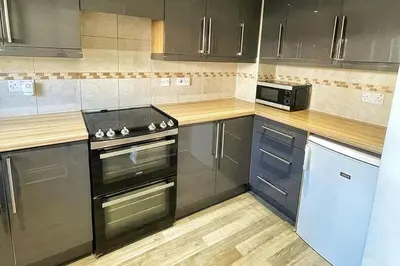 a kitchen with a stove and a microwave at Modern 3 Bed House In Essex By DLuxoria Short Lets & Serviced Accommodation With Pet Friendly, Free WiFi & Free Parking in Basildon