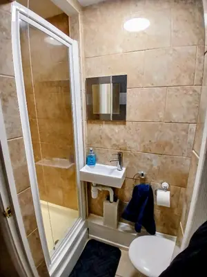 a small bathroom with a sink and a shower at Ipswich Town 3 Bed House in Copdock