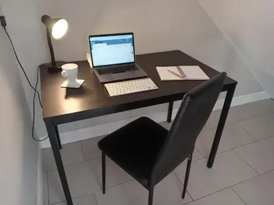 a laptop computer sitting on a desk with a chair at Ipswich Town 3 Bed House in Copdock