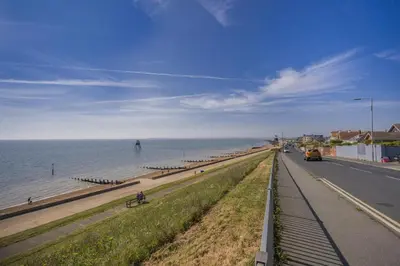 a road next to a beach with the ocean at 4 Bed in Harwich oc-s30791 in Harwich