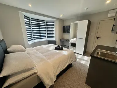a bedroom with a bed with a sink and a window at Captivating 7 -Bed House in Waltham Abbey in Waltham Abbey