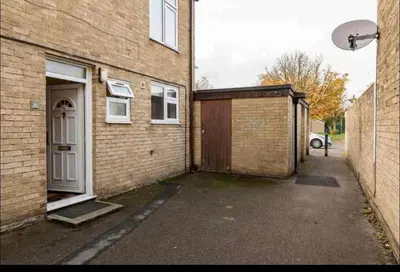a brick building with a garage next to a house at Nice and spacious room in Chesterton
