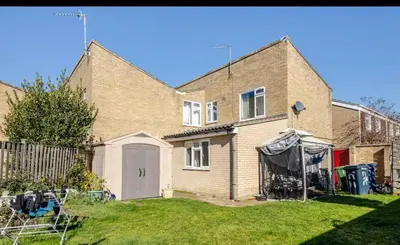a brick house with a white door in a yard at Nice and spacious room in Chesterton