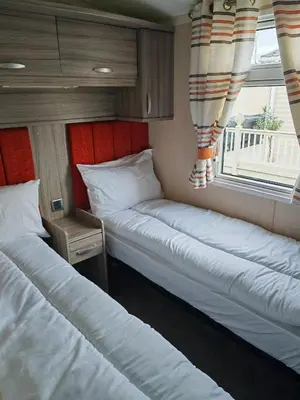two beds in a small room with a window at Green House Moselle in Jaywick Sands