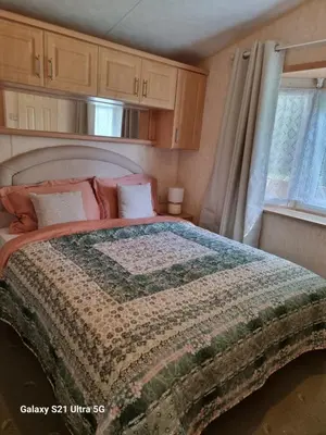 a bedroom with a bed with a quilt on it at The Fox - Free Fishing, pets welcome - static caravan in Clare, Suffolk in Clare