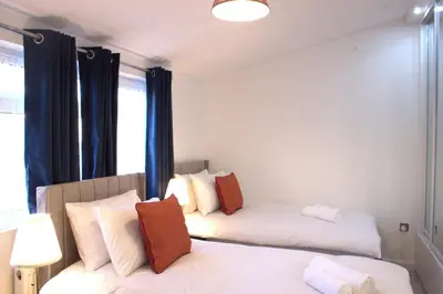 a bedroom with two beds and a mirror at Luxury 3 bedroom house in Harlow, Essex in Harlow