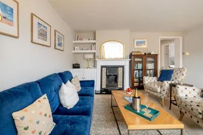 a living room with a blue couch and a table at The Nest, Aldeburgh - Prime location close to the beach and town amenities - Aldeburgh Coastal Cottages in Aldeburgh