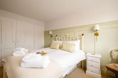 a bedroom with a white bed with towels on it at The Nest, Aldeburgh - Prime location close to the beach and town amenities - Aldeburgh Coastal Cottages in Aldeburgh