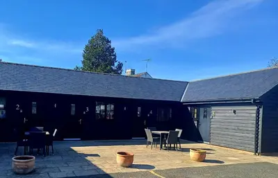a building with a table and chairs in a patio at the walnut tree in Worlington