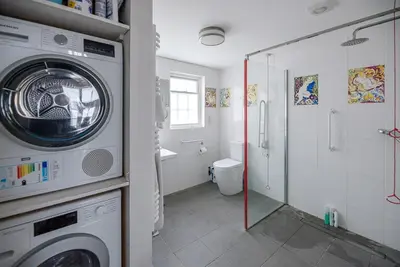 a bathroom with a washer and dryer in a room at Art Cottage, Aldeburgh in Aldeburgh