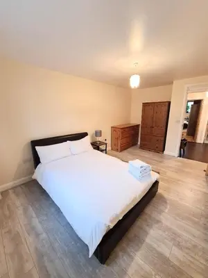 a bedroom with a large white bed and a wooden floor at Modern Cambridge Flat-Easy A14 Access and City Links in Milton