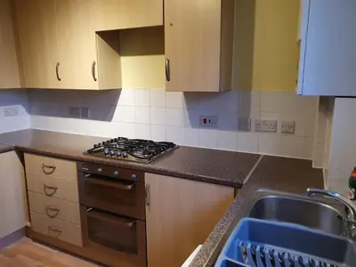 a kitchen with a stove top oven next to a sink at Modern Cambridge Flat-Easy A14 Access and City Links in Milton