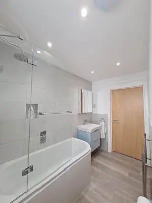 a white bathroom with a tub and a sink at Modern Cambridge Flat-Easy A14 Access and City Links in Milton