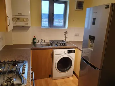 a kitchen with a washing machine and a sink at Modern Cambridge Flat-Easy A14 Access and City Links in Milton