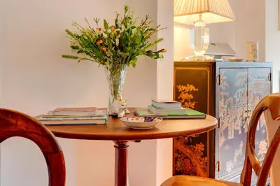 a table with a vase of flowers on it at Pass the Keys Charming Cottage in the City Centre Free Parking in Cambridge