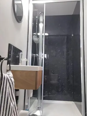 a bathroom with a glass shower with a sink at The Nook in Great Cornard