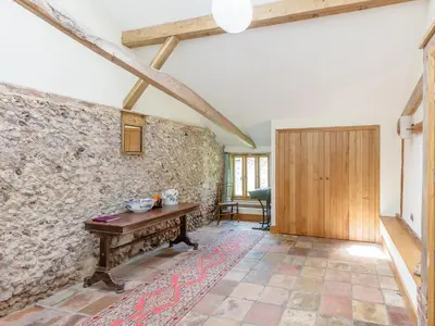 a room with a table and a stone wall at Colemans Farm Barn- Unique, Rustic & Peaceful Barn - Essex countryside in Finchingfield