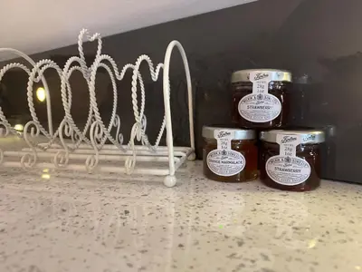 three jars of honey on a counter next to a rack at Primrose Lodge in Maldon in Maldon