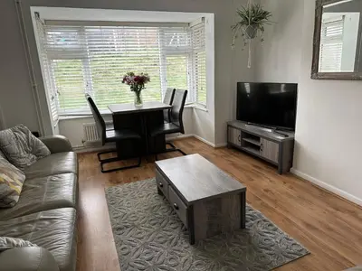 a living room with a table and chairs and a television at Place to stay up Ipswich near the train station, football stadium, waterfront in Ipswich