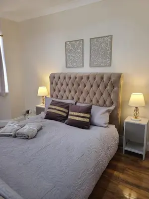 a large bed in a bedroom with two lamps at One Bed and Bath in Rochford in Rochford