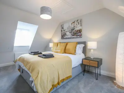 a bedroom with a large bed with yellow pillows at 51 Halesworth in Holton