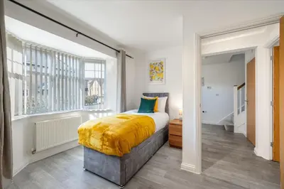 a bedroom with a bed and a window at Cambridge 5 Bedrooms Sleeps 10 Free Parking 4 Bathrooms in Long Stanton
