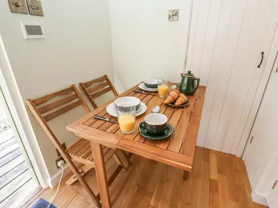 a wooden table with two plates of food and orange juice at Woodlands Retreat Shepherd's Hut in Woodbridge