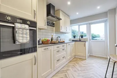 a kitchen with white cabinets and a large window at Cozy Modern Home Basildon Long stay Contractors Sleeps 6 in Basildon