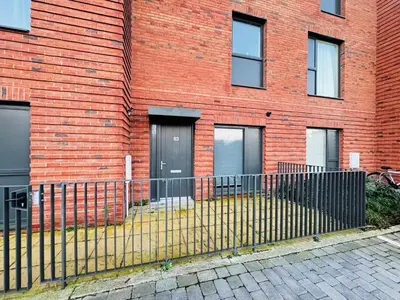 a fence in front of a brick building at Cambridge Urban Suite in Cambridge