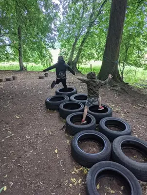 two children playing on tires in a park at Hertford belltent farm stay riverside firepit bbq in Hertford