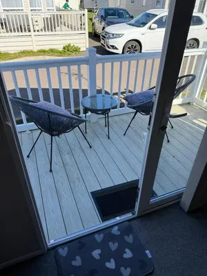 a balcony with two chairs and a table on a deck at Mimosa holiday home in Little Clacton
