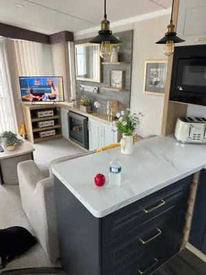 a kitchen and living room with a white counter top at Mimosa holiday home in Little Clacton