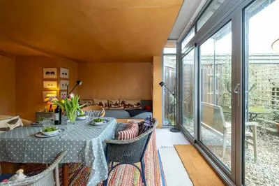 a living room with a table and chairs at Wodehouse, Eco House - Aldeburgh Coastal Cottages in Aldeburgh