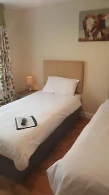 a bedroom with two beds with a book on the bed at The Old Grain Store Bed & Breakfast in Pidley