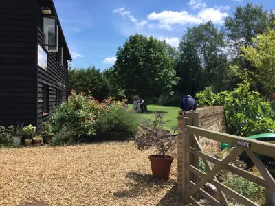a garden with a fence and flowers and a house at The Old Grain Store Bed & Breakfast in Pidley