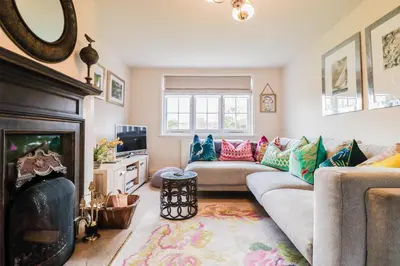 a living room with a couch and a fireplace at Beautifully Designed Cottage Free WiFi in Rivenhall