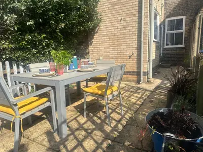 a white table with two chairs and a table with food on it at Hurrell Cottage in Cambridge