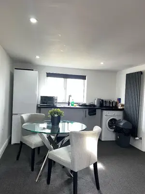 a kitchen with a table and chairs in a kitchen at Modern Studio Flat In A Guest House In Basildon in Basildon