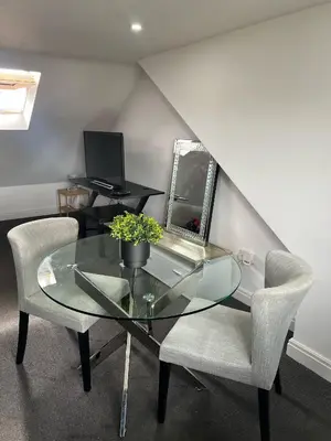 a glass table and a chair and a mirror at Modern Studio Flat In A Guest House In Basildon in Basildon