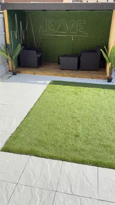 a patch of green grass in front of a building at Paramount Luxe Loft- 3 bedrooms, 4 beds cosy home in Laindon