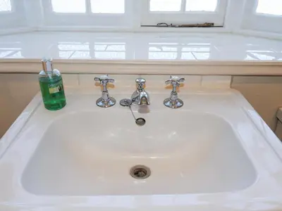 a white sink with a soap bottle on top of it at Holm Oak Lodge in Clacton-on-Sea