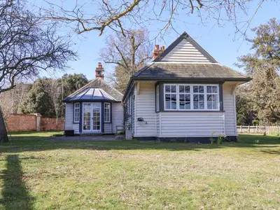 an old house in a field with a yard at Holm Oak Lodge in Clacton-on-Sea