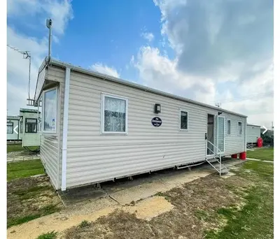 a large white trailer parked in a yard at House of Eminence Holidays in Saint Osyth