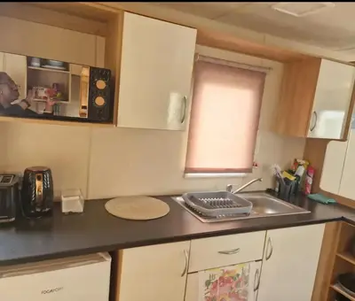 a kitchen with a sink and a counter top at House of Eminence Holidays in Saint Osyth