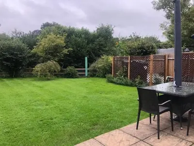 a table and chairs in a yard with a green lawn at Beautifully refurbished 3 bedroom cottage in Ashdon