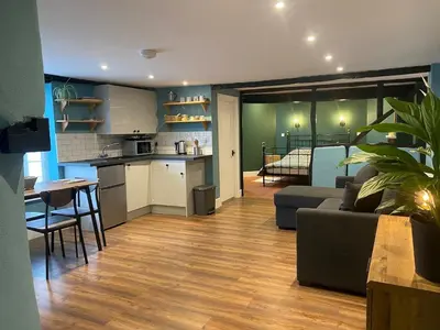 a kitchen and living room with a couch and a table at The Old King Bill in Fenstanton