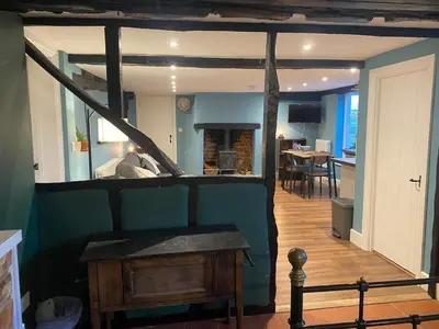a room with a staircase and a living room with a table at The Old King Bill in Fenstanton