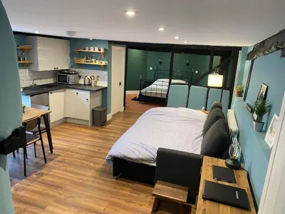 a kitchen and a bedroom with a bed and a table at The Old King Bill in Fenstanton