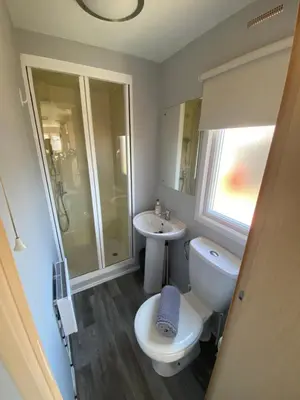 a bathroom with a toilet and a sink at Highfield Grange Holiday Park Clacton in Little Clacton