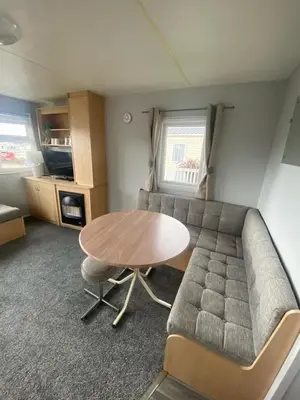 a living room with a table and a couch at Highfield Grange Holiday Park Clacton in Little Clacton
